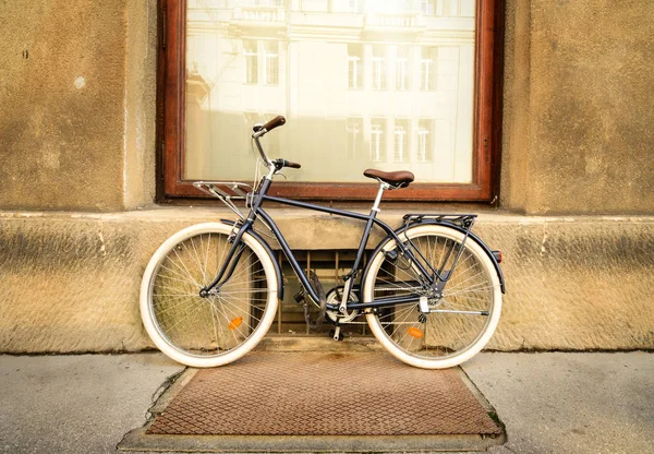 A beautiful city bike fastened to a metal fence.