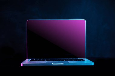 Siyah bir arka plan üzerinde taşınabilir modern gümüş bilgisayar.