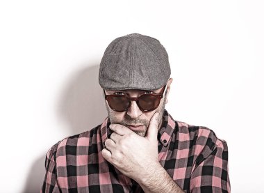 Şüpheli yetişkin adam ekose gömlekli, gözlük ve bir kap beyaz bir arka plan üzerinde şüphe.