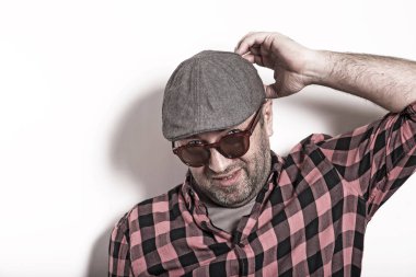 Şüpheli yetişkin adam ekose gömlekli, gözlük ve bir kap beyaz bir arka plan üzerinde şüphe.