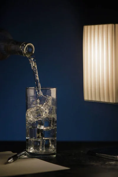 Glass Musserende Vann Med Mørkt Bord Med Penn Papirark Skrivebordslampe – stockfoto
