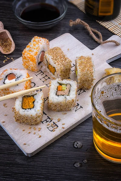 Sushi Uma Placa Madeira Com Copo Cerveja Molho Soja Pauzinhos — Fotografia de Stock