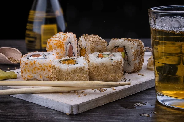 Sushi Uma Placa Madeira Com Copo Cerveja Molho Soja Pauzinhos — Fotografia de Stock