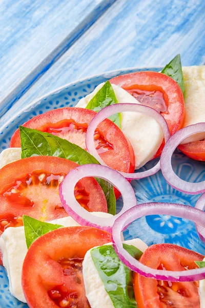 Süs mavi bir tablo içinde bir restoran ile mavi tabakta Caprese salatası.