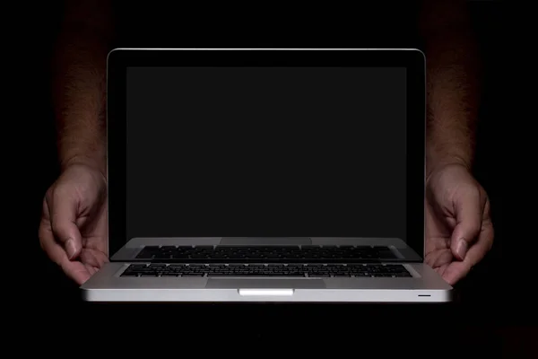 Portable modern silver computer on a black background. Computer in male hands.