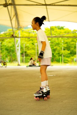 Asian teen girl roller skating. Roller-skating. High quality photo