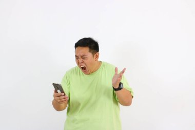 Asyalı genç bir adamın telefon görüşmesinde öfke ve hayal kırıklığı gösteren portresi..