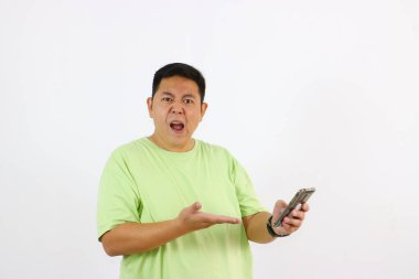 Genç bir adam elinde telefon tutarken öfke ve hayal kırıklığını ifade eder..