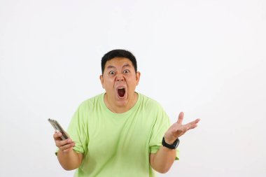 Asyalı genç adam elinde kızgın bir ifadeyle ve hayal kırıklığına uğramış hareketlerle telefonu tutuyor..