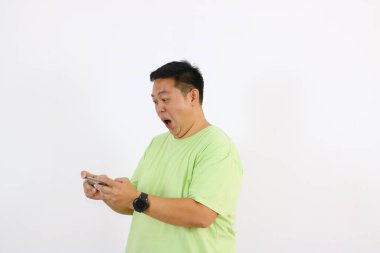 Asyalı genç bir adamın telefon görüşmesinde öfke ve hayal kırıklığı gösteren portresi.