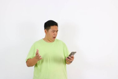 Genç bir adamın yüzü telefonu tutarken merak ve şüpheyi yansıtır..