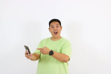 Parmakla işaret eden ve akıllı telefonu tutan şaşırmış adam.