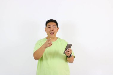 Akıllı telefonuyla seni işaret eden bir adam şaşkınlık ve fikir jesti gösteriyor.