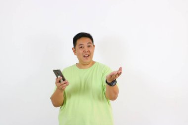 Elinde telefonla yukarı bakan adam heyecanlı görünüyor.