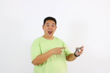 Adam heyecanlı bir ifadeyle cep telefonunu işaret ediyor.