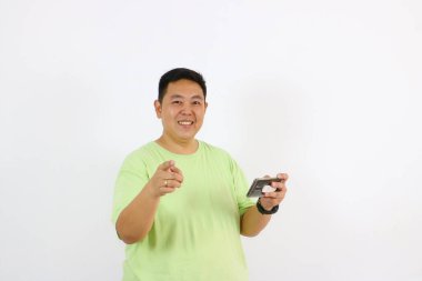 Adam şaşırmış bir ifadeyle telefonu işaret ediyor.