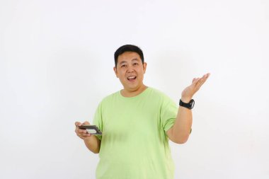 Gülümseyen adam akıllı telefonu tutuyor ve kamerayı işaret ediyor.