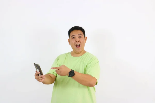 Parmakla işaret eden ve akıllı telefonu tutan şaşırmış adam.