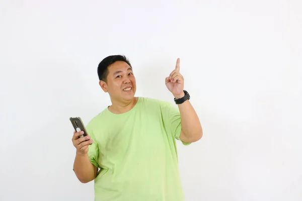 Asyalı bir adam akıllı bir telefon tutuyor ve gülümsüyor.