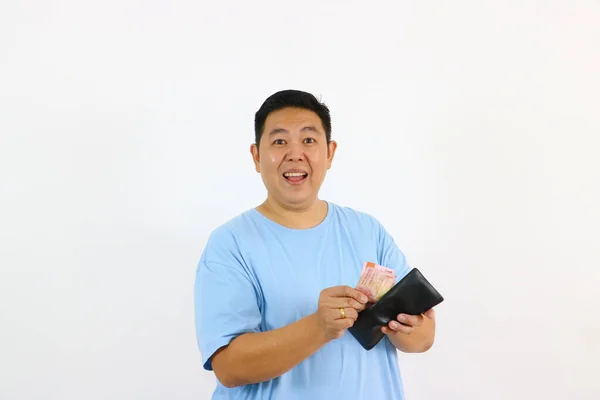 Cüzdandan para sayan ve kameraya gülümseyen adam