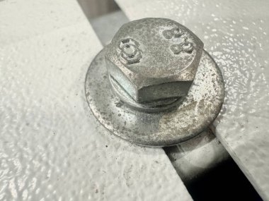 Metal cıvatayı endüstriyel inşaat konseptinde çelik yüzeye sabitleyerek kapat