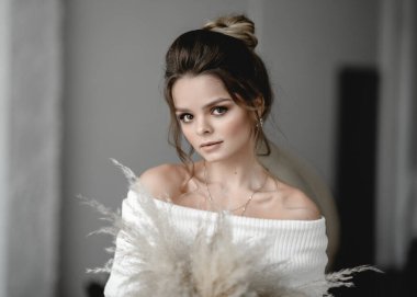 Parlak bir iç mekânda çiçeklerle güzel, nazik bir kız bahar mevsiminde taze bir görüntü.