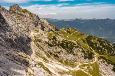 Bavyera Alpleri 'ndeki Alpspitze Via Ferrata' dan Rocky yamaçları ve açık mavi gökyüzü altındaki yeşil vadilerle manzaralı dağ yolu. Yüksek kalite fotoğraf