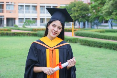 Genç Asyalı kadın üniversite mezunları sevinçle kutluyor.