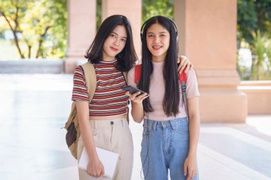 Asyalı üniversite öğrencileri üniversite kampüsünde sohbet ediyor, konuşuyor..