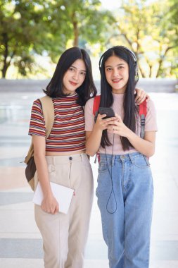 Asyalı üniversite öğrencileri üniversite kampüsünde sohbet ediyor, konuşuyor..