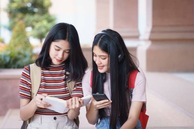 Asyalı üniversite öğrencileri üniversite kampüsünde sohbet ediyor, konuşuyor..