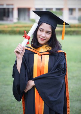 Genç Asyalı kadın üniversite mezunları, mezuniyet töreninde üniversite diploması aldıktan sonra arkadaşlarıyla keyifli ve mutlu bir kutlama yapıyor. Tebrikler, mezuniyet töreni..