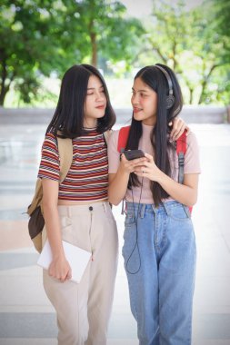 Asyalı üniversite öğrencileri üniversite kampüsünde sohbet ediyor, konuşuyor..