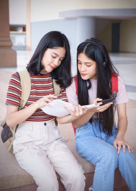 Asyalı üniversite öğrencileri üniversite kampüsünde sohbet ediyor, konuşuyor..