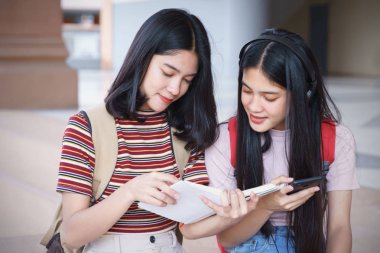 Asyalı üniversite öğrencileri üniversite kampüsünde sohbet ediyor, konuşuyor..