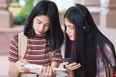 Asyalı üniversite öğrencileri üniversite kampüsünde sohbet ediyor, konuşuyor..