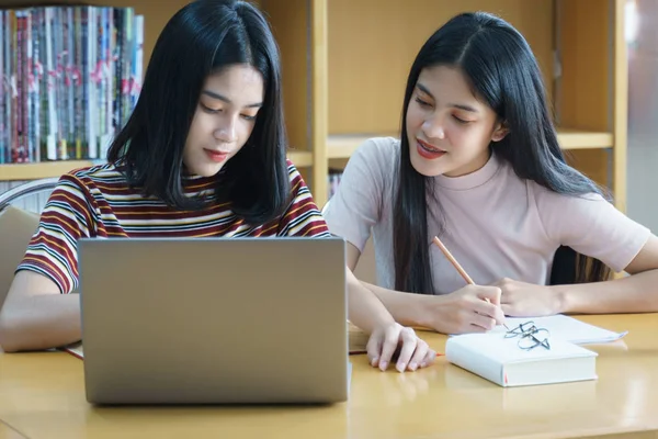 Joven mujer asiática estudiante estudio y tomar notas con libro en libr — Foto de Stock