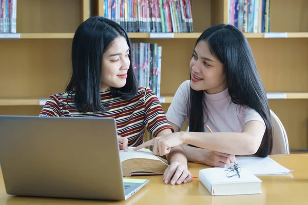 Joven mujer asiática estudiante estudio y tomar notas con libro en libr —  Fotos de Stock