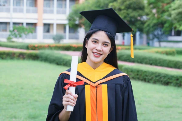Young Asian woman university graduates celebrate with joyouse an