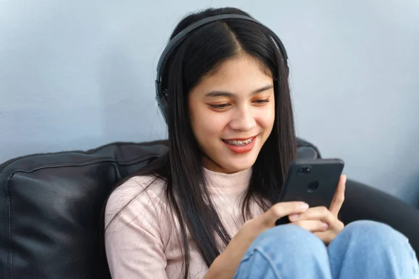 Asian teenager spend free time reading book and playing with cel