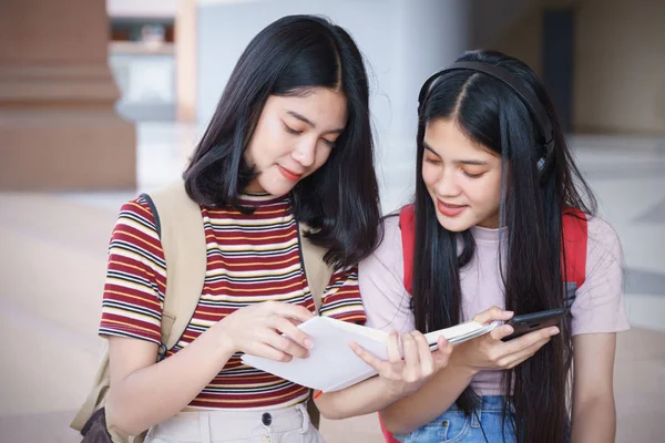 Asyalı üniversite öğrencileri üniversite kampüsünde sohbet ediyor, konuşuyor..