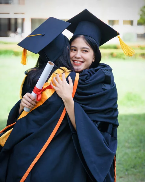 Jovem asiática graduados universitários celebram com alegria e felicidade com os amigos depois de receber um certificado de diploma universitário na cerimônia de início. Parabéns, cerimônia de formatura . — Fotografia de Stock