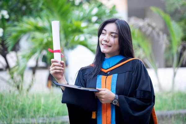若いアジアの女性大学卒業生の幸せと興奮の肖像画は卒業のガウンと帽子を着用し 初日に大学のキャンパスで学位を祝う 教育理念 — ストック写真