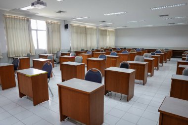 Antika ahşap sandalyeli boş bir sınıf. COVID-19 salgınını önlemek için sosyal mesafeleme konseptinde sınıf düzenlemesi. Okul konseptine dönelim..