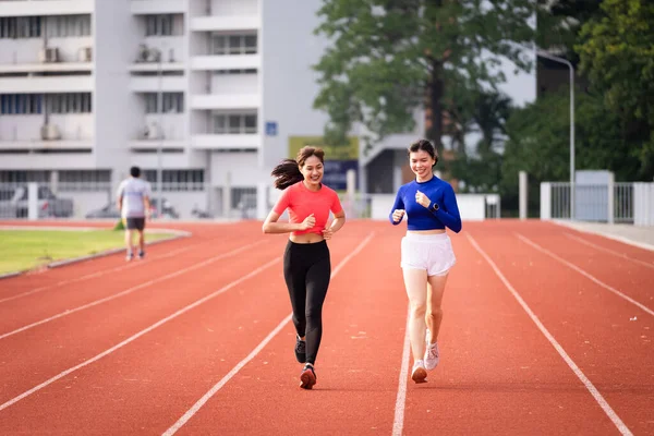 Genç fitness kadın koşucusu sabah şehir stadyumundaki pistte egzersiz yapıyor. Vücut sağlığını korumak için stadyumda kadın sporcu egzersizi. Sağlık ve Rekreasyon Stoku fotoğrafı.