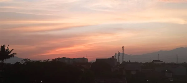 Ev ve Kulelerin Silueti ile Kızıl Gün Batımı