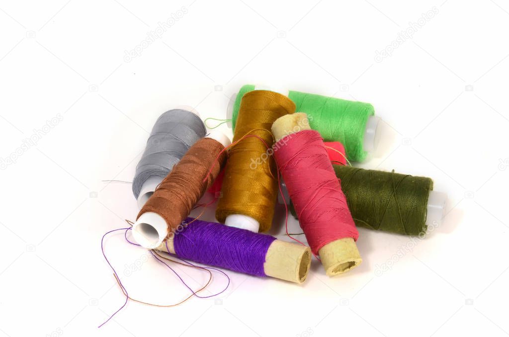 A set of coils with different colored threads on white background 