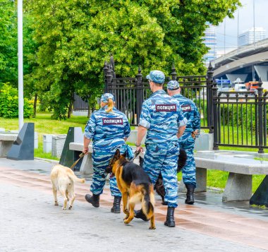Rusya, Moskova - 12 Temmuz 2016: Ulusal Ekonominin Başarıları Sergisi yakınlarındaki parkta devriye gezen polis ve köpekler. 