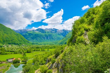 Yüksek karla kaplı kayalar arasında doğal yeşil çayır