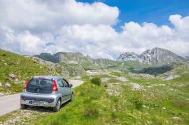 Karadağ, Durmitor - 07 Haziran 2017: turist Park edilmiş araba üzerinde yüksek dağlar yol kenarı 